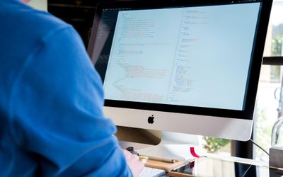 Person sitzt vor einem Computerbildschirm