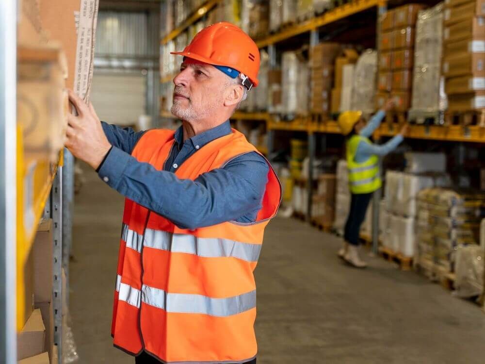 Mann mit Schutzkleidung im Lager